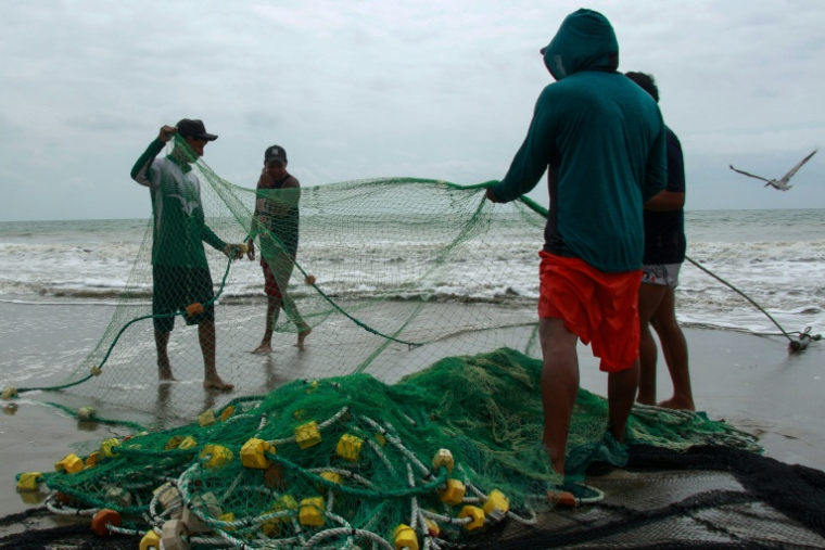 Des pêcheurs manipulent des filets à Santa Elena, en Equateur, le 18 septembre 2026  ( AFP / Gerardo MENOSCAL )