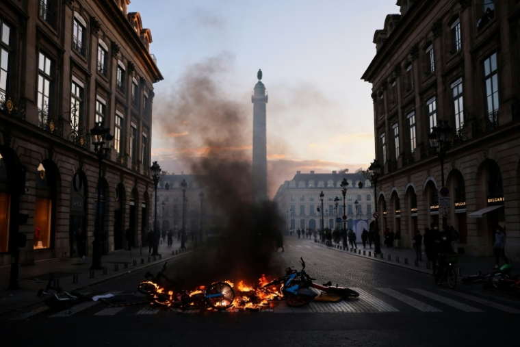 Des vélos en libre-service incendiés lors d'une manifestation contre la vie chère à Paris, le 17 octobre 2026 ( AFP / Kiran RIDLEY )
