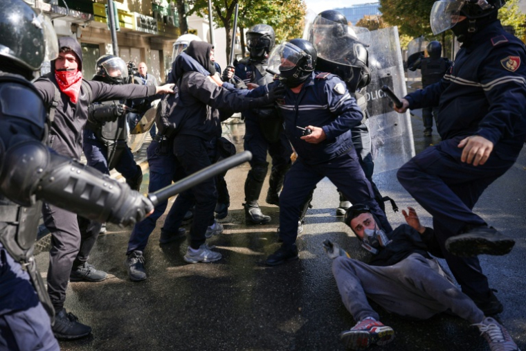 Un manifestant au sol, interpellé par des policiers, lors d’une manifestation antigouvernementale à Tirana, le 16 octobre 2026 en Albanie ( AFP / Adnan Beci )