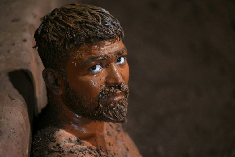 Un lutteur, couvert d'huile de moutarde et de sable, après un entraînement dans un gymnase à Kolhapur, dans l'État du Maharashtra, le 30 avril 2025 en Inde ( AFP / Indranil MUKHERJEE )
