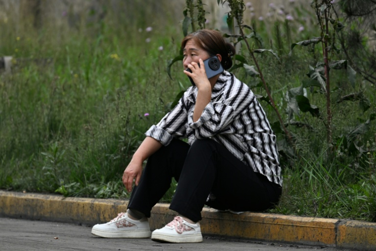Une proche attend des nouvelles d'un mineur porté disparu après un coup de grisou dévastateur qui a tué au moins 82 ouvriers, le 24 mai 2026 dans le district administratif de Qinyuan, dans la province chinoise septentrionale du Shanxi ( AFP / GREG BAKER )