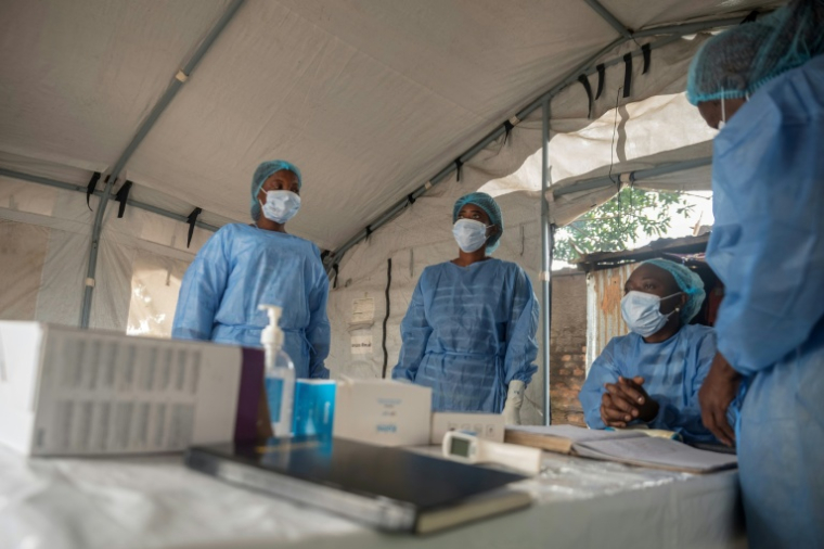 Des agents de santé attendent pour contrôler les voyageurs arrivant au débarcadère de M’Poko Bac, dans le district de Bimbo, au sud-ouest de Bangui, le 28 octobre 2026 en Centrafrique ( AFP / - )