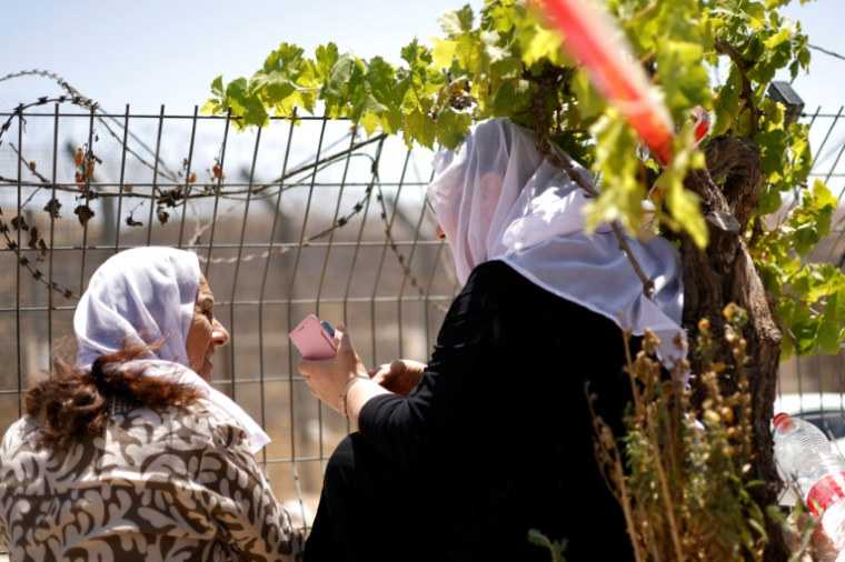 Des femmes druzes attendent près de la barrière frontalière entre Israël et la Syrie, à Majdal Shams, sur le plateau du Golan annexé par Israël, le 17 juillet 2025 ( AFP / Jalaa MAREY )
