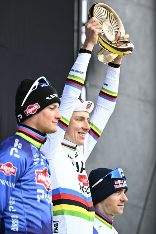 Le coureur slovène de l'équipe UAE, Tadej Pogacar (au centre), célèbre sa victoire au Tour des Flandres 2026, entouré sur le podium du Néerlandais Mathieu van der Poel (à gauche), de l'équipe Alpecin, deuxième, et du Belge Remco Evenepoel (à droite), de l'équipe Red Bull, troisième, à Haaltert, le 5 avril 2026 ( BELGA / ERIC LALMAND )