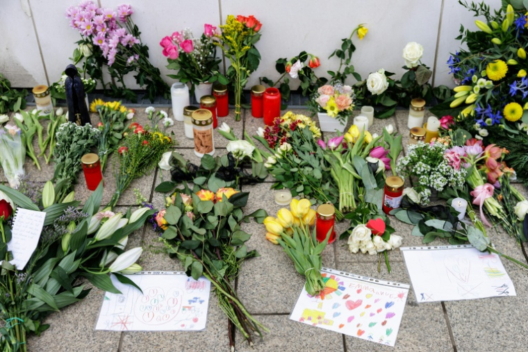 Des fleurs, des bougies et des messages ont été placés au sol devant une église à Leipzig, en Allemagne le 5 mai 2026, où une voiture-bélier a fauché des passants la veille, faisant deux morts ( AFP / Jens SCHLÜTER )