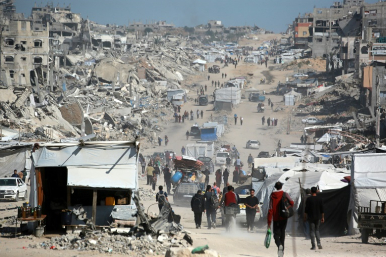 Des Palestiniens transportant quelques biens fuient la ville de Gaza, le 16 mai 2025 ( AFP / Bashar TALEB )