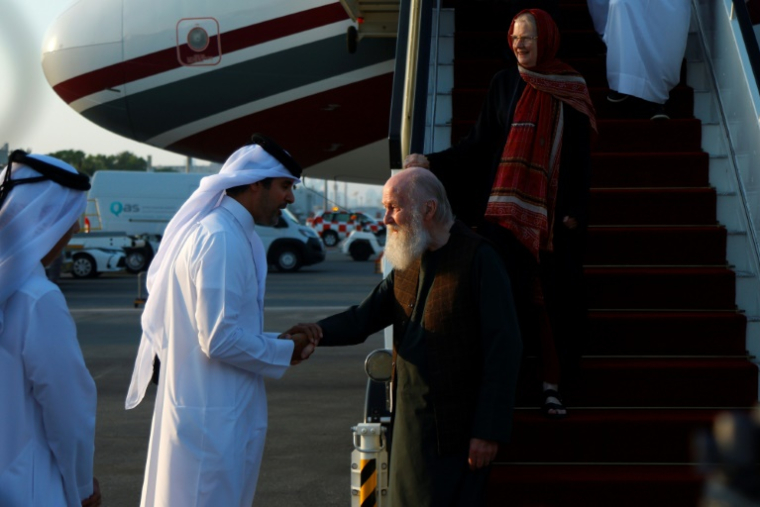 Un responsable qatari accueille les Britanniques Peter Reynolds et son épouse Barbie à leur arrivée à l'aéropot de Doha, après leur libération pour les autorités talibanes, le 19 septembre 2025 ( AFP / Karim JAAFAR )