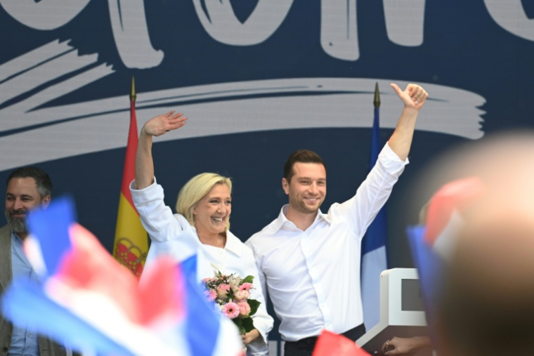 La présidente du groupe parlementaire du Rassemblement national (RN), Marine Le Pen (g), et le président du RN, Jordan Bardella (d), saluent le public à l'issue d'une réunion du groupe Patriotes pour l'Europe au Parlement européen, réunissant des dirigeants européens d'extrême droite, à Mormant-sur-Vernisson, le 9 juin 2025 dans le Loiret ( AFP / JEAN-FRANCOIS MONIER )