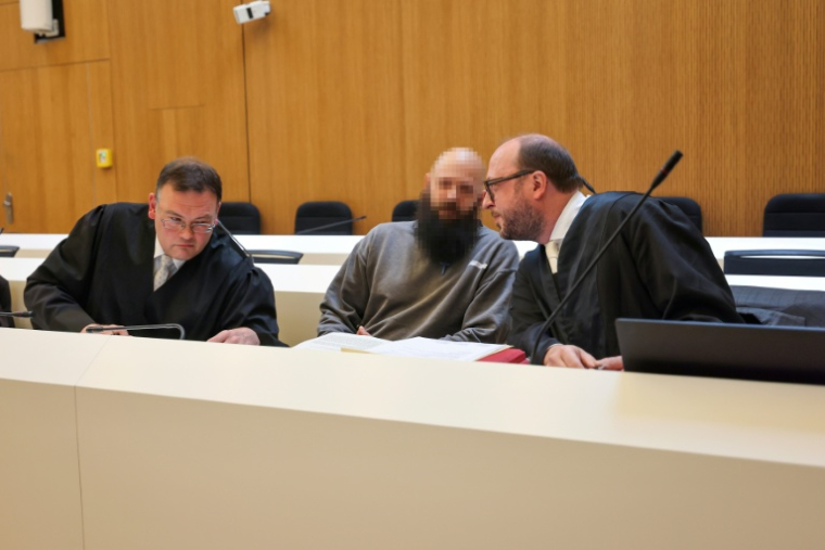 Le prévenu Dieter S. est assis entre ses avocats Stephan Schultheis (g) et Michael Loewe (d) à son arrivée au tribunal de Munich, dans le sud de l'Allemagne, le 20 mai 2025 ( AFP / Alexandra BEIER )