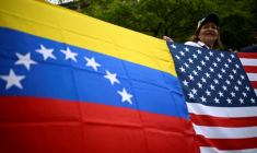 Une femme tient les drapeaux du Venezuela et des États-Unis lors d’une manifestation sur la place Alfredo Sadel, à Caracas, le 16 avril 2026, pour exiger des élections au Venezuela ( AFP / Federico PARRA )