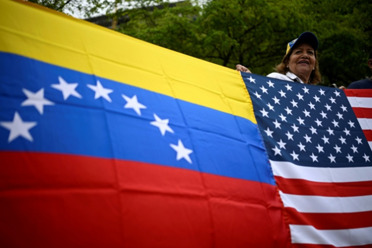 Une femme tient les drapeaux du Venezuela et des États-Unis lors d’une manifestation sur la place Alfredo Sadel, à Caracas, le 16 avril 2026, pour exiger des élections au Venezuela ( AFP / Federico PARRA )