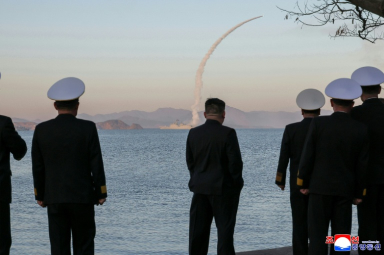 Photo prise le 12 avril 2026 et diffusée par l'agence de presse officielle nord-coréenne KCNA le 14 avril 2026, montrant le dirigeant nord-coréen Kim Jong Un (c) observant des tirs d'essai de missiles de croisière depuis le destroyer Choe Hyon, dans un lieu non divulgué en Corée du Nord ( KCNA VIA KNS / STR )