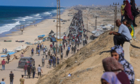 Des Palestiniens marchent sur la route al-Rachid en direction de la ville Gaza, après l'annonce du cessez-le-feu dans la bande de Gaza, le 10 octobre 2025 ( AFP / BASHAR TALEB )