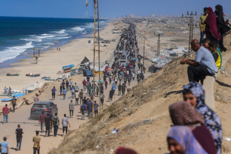 Des Palestiniens marchent sur la route al-Rachid en direction de la ville Gaza, après l'annonce du cessez-le-feu dans la bande de Gaza, le 10 octobre 2025 ( AFP / BASHAR TALEB )
