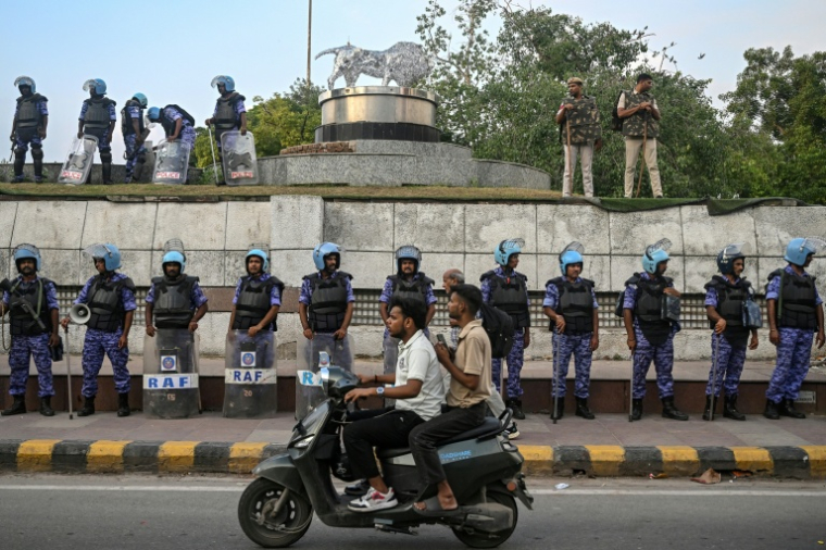 La police indienne monte la garde à New Delhi, le 23 juillet 2026, alors qu’une manifestation se poursuit pour réclamer la démission du ministre indien de l’Éducation et protester contre les fraudes aux examens ( AFP / Arun SANKAR )