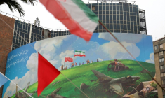 Dans le centre de Téhéran, le drapeau iranien flotte devant un vaste panneau anti-américain, le 8 février 2026 ( AFP / ATTA KENARE )