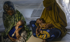 Des femmes somaliennes récemment déplacées tiennent dans leurs bras leurs bébés souffrant de malnutrition sévère dans un centre de santé, à Kismayo, le 22 avril 2026  ( AFP / SIMON MAINA )