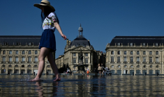 Une femme se rafraîchit en pleine vague de chaleur dans le "miroir d'eau" de Bordeaux le 8 août ( AFP / Philippe LOPEZ )