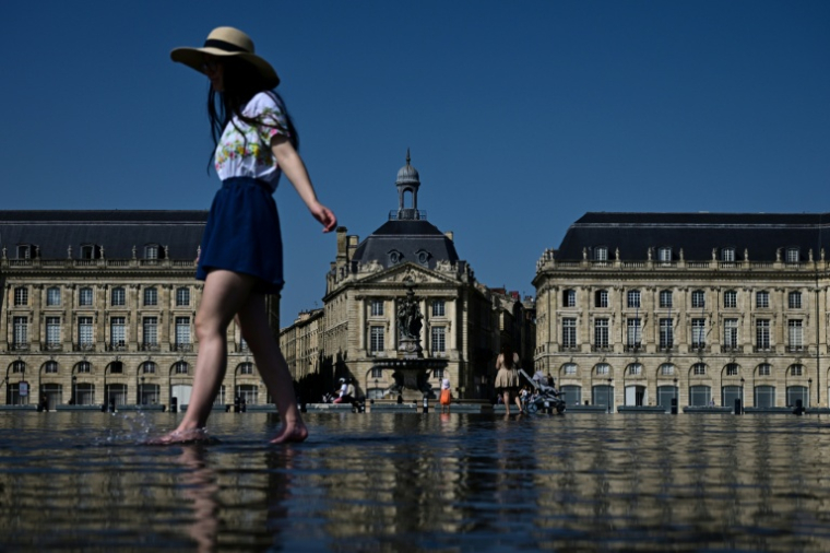 Une femme se rafraîchit en pleine vague de chaleur dans le "miroir d'eau" de Bordeaux le 8 août ( AFP / Philippe LOPEZ )