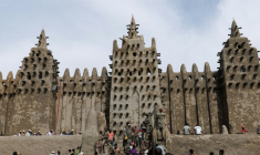 Des personnes utilisent du banco, un enduit de terre, pour le crépissage annuel de la grande mosquée de Djenné le 12 juin 2025 ( AFP / OUSMANE MAKAVELI )
