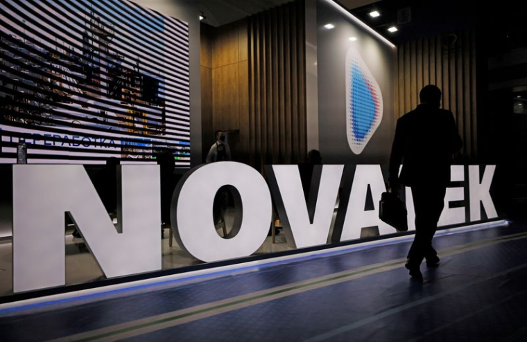 Un participant à un forum passe devant un stand du producteur de gaz russe Novatek