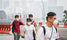 Des piétons portent des masques de protection dans une rue de Singapour, alors que le pays est noyé dans une brume causée par des incendies en Indonésie, le 16 octobre 2026 ( AFP / Yuichi YAMAZAKI )