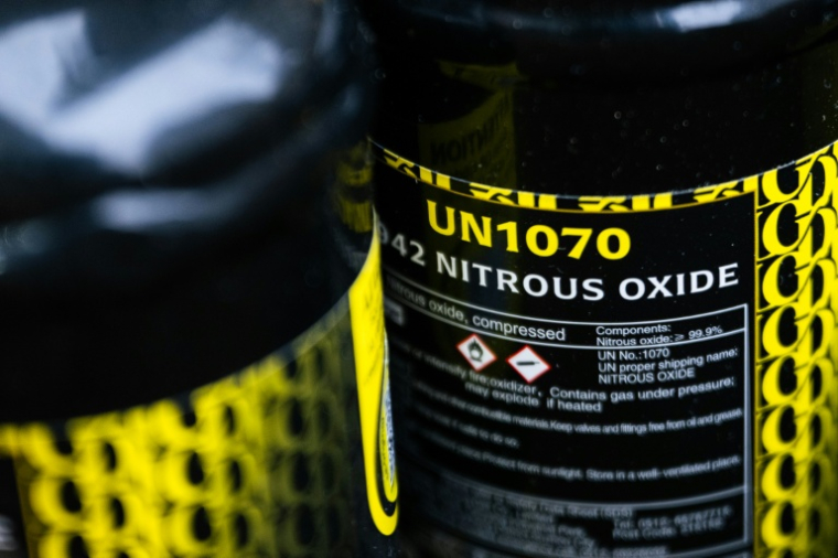 Des bonbonnes de protoxyde d'azote abandonnées dans une rue de Paris, le 15 janvier 2026 ( AFP / Julie SEBADELHA )