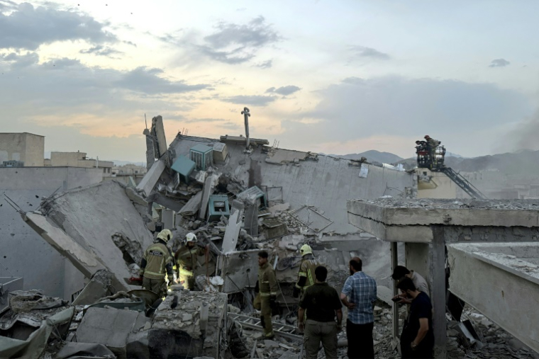 Des habitants et des secouristes se rassemblent sur un bâtiment touché par une frappe israélienne à Téhéran, le 13 juin 2025 ( TASNIM NEWS / MEGHDAD MADADI )