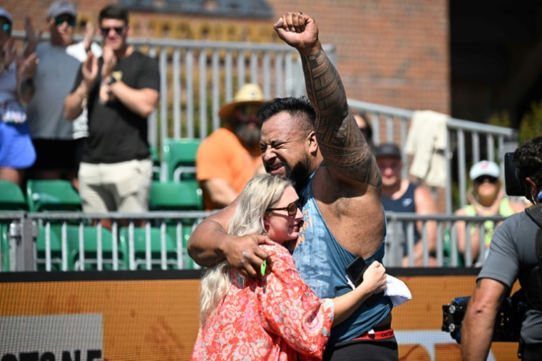 Eddie Williams enlace sa feme Hannah après s'être qualifié pour la finale du concours de "L'homme le plus fort du monde", le 16 mai 2025 à Sacramento, en Californie ( AFP / Robyn Beck )