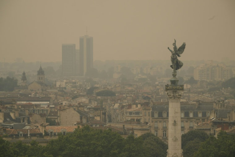 Cette photographie montre la fumée provenant d’incendies de forêt voisins recouvrant la ligne d’horizon de la ville de Bordeaux, le 26 juillet 2026 ( AFP / Ed JONES )