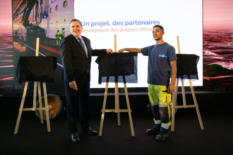 Le ministre des Transports Philippe Tabarot (G) et un ouvrier du scteur portuaire lors de l'inauguration du dispositif de branchement électrique des bateaux de croisière, le 11 avril 2026 à Marseille  ( AFP / CLEMENT MAHOUDEAU )