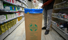Un homme jette des médicaments non utilisés dans une boîte en carton de l'organisme Cyclamed, chargé de leur collecte, le 23 mars 2023 dans une pharmacie à Colomiers ( AFP / Valentine CHAPUIS )