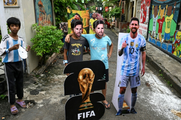 A Kolkata en Inde, des fans de Lionel Messi posent avec des masques de leur idole pour fêter son 39e anniversaire, le 24 juin. ( AFP / Dibyangshu SARKAR )