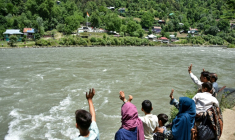 Une famille du village de Keran, partagé entre le Cachemire pakistanais et le Cachemire indien, de l'autre côté de la rivière Neelum, le 29 mai 2026 ( AFP / Sajjad QAYYUM )