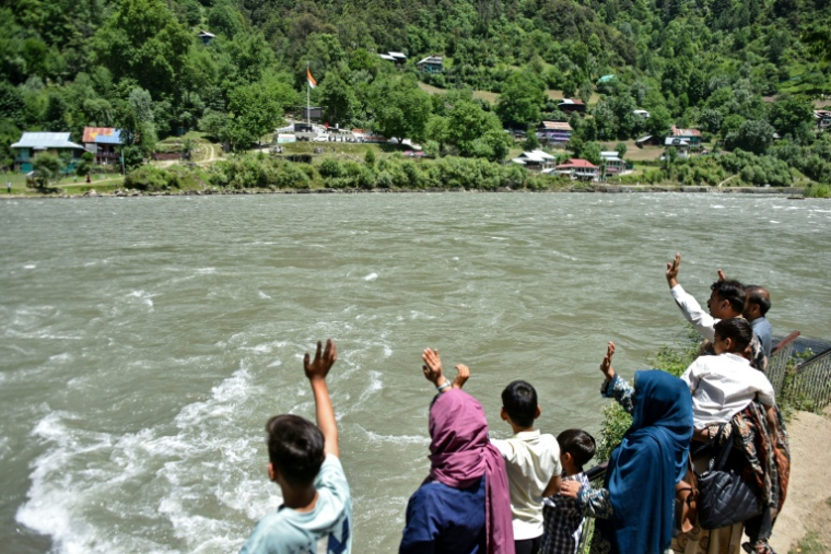 Une famille du village de Keran, partagé entre le Cachemire pakistanais et le Cachemire indien, de l'autre côté de la rivière Neelum, le 29 mai 2026 ( AFP / Sajjad QAYYUM )