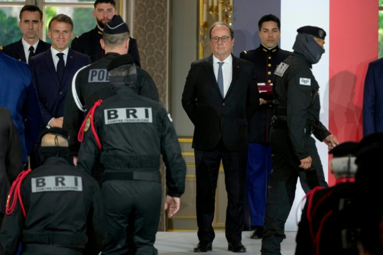 Le président Emmanuel Macron (2e g) et son prédécesseur François Hollande (2e d) assistent à une cérémonie en l'honneur des policiers intervenus au Bataclan pendant attentats du 13 novembre 2015, à l'Élysée, le 21 avril 2026 à Paris ( POOL / Michel Euler )
