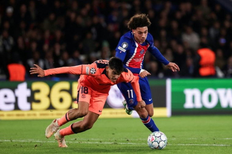 Le Parisien Maghnes Akliouche (d), au duel avec le Barcelonais Gerard Martin, le 20 octobre 2026 au Parc des Princes ( AFP / FRANCK FIFE )