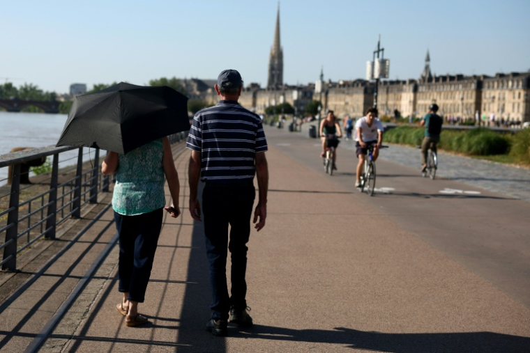 Des passants à Bordeaux le 17 juin 2026 pendant une vague de chaleur ( AFP / ROMAIN PERROCHEAU )