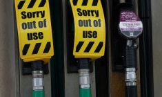 Des panneaux indiquant que les pompes à essence sans plomb sont hors d'usage sont suspendus aux becs des pompes vides sur le parvis d'une station-service à Manchester