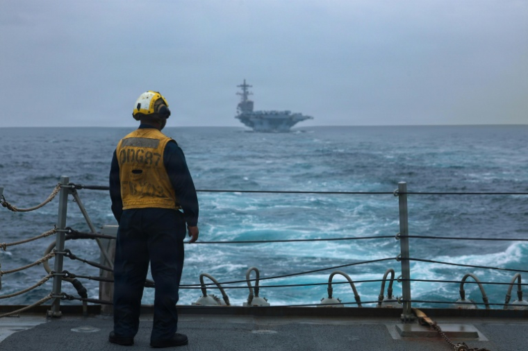 Photo diffusée diffusée par le Commandement central des forces navales des États-Unis, le 9 septembre 2026, montrant un marin américain debout sur le pont d'envol du destroyer lance-missiles de classe Arleigh Burke USS Mason, le 4 septembre 2026 en mer ( US NAVY / Handout )