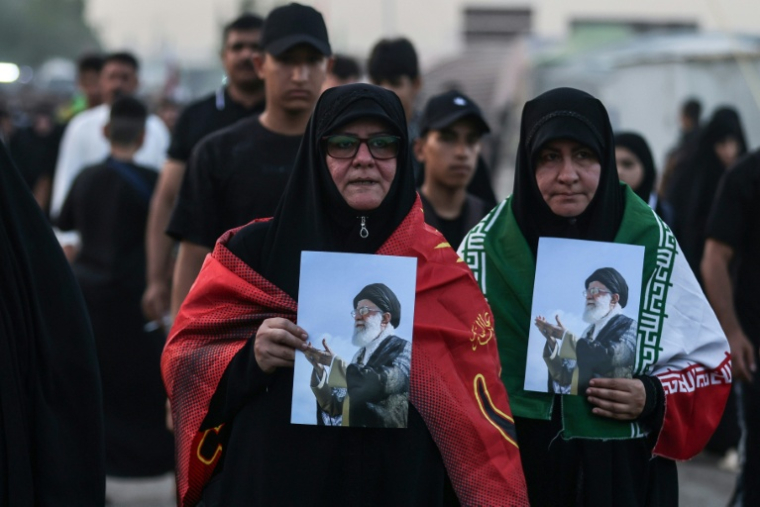 Des pèlerins chiites portent le portrait de l'ancien guide suprême iranien Ali Khamenei dans les rues de Bagdad en Irak, à l'occasion de la célébration d'Arbaïn, le 30 juillet ( AFP / AHMAD AL-RUBAYE )
