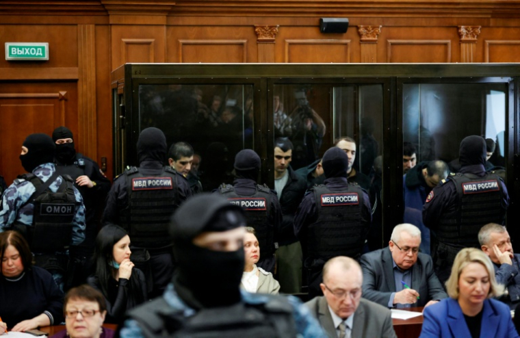 Les accusés, soupçonnés d'implication dans l'attentat perpétré en 2024 à la salle de concert Crocus City Hall, dans des box vitrés avant l'annonce de leur verdict par un tribunal de Moscou, le 12 mars 2026 ( AFP / TATYANA MAKEYEVA )