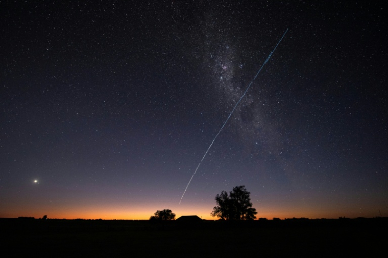 Une photo en pose longue montre une traînée lumineuse laissée par un groupe de satellites Starlink de SpaceX survolant l'Uruguay, avec une partie de la Voie lactée et la planète Vénus (g) visibles dans le ciel, à environ 185 km au nord de Montevideo, le 12 novembre 2023 ( AFP / Mariana SUAREZ )