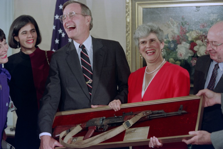 Violeta Chamorro (D), présente au président américain George Bush un AK-47 censé avoir été confisqué à la guérilla des Contras, en rébellion dans les années 80 contre le pouvoir des Sandinistes avec le soutien des Etats-Unis, avant leur rencontre bilatérale le 29 septembre 1990 à New-York ( AFP / Jerome DELAY )