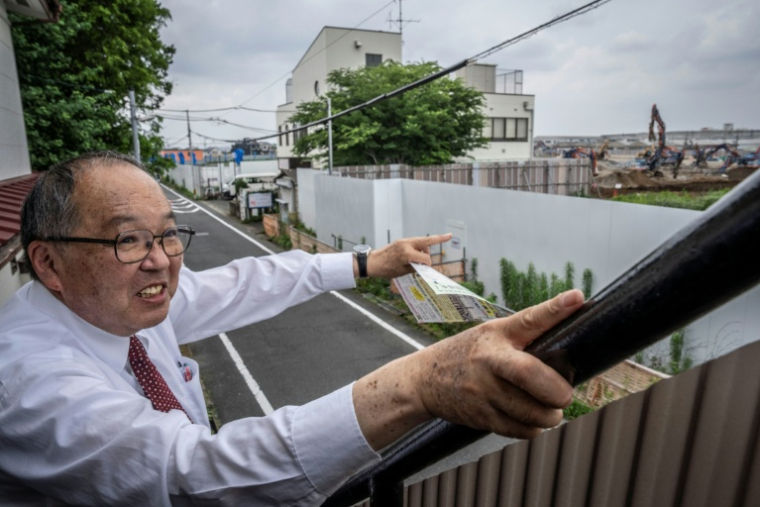 Yasuo Yamazaki, représentant d'un collectif de citoyens inquiets de la construction d'un centre de données, montre le site du projet à Hino, dans la préfecture de Tokyo, au Japon, le 30 juin 2026  ( AFP / Yuichi YAMAZAKI )