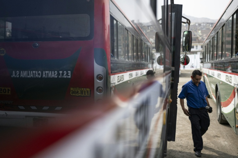 Un chauffeur de bus sort de son véhicule dans le district populaire de San Juan de Lurigancho, le 8 avril 2026 à Lima ( AFP / ERNESTO BENAVIDES )