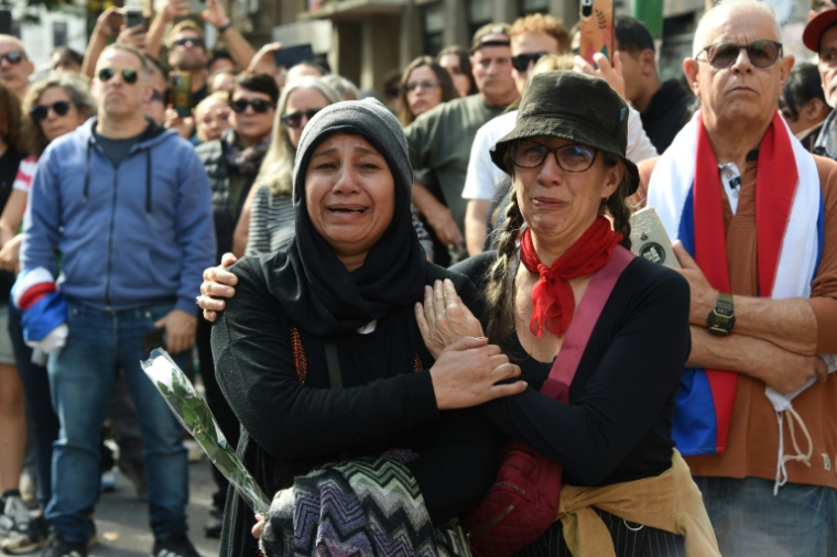 Des femmes pleurent alors que le cortège funèbre de l'ancien président uruguayen José "Pepe" Mujica traverse l'avenue Libertador dans le centre de Montevideo, le 14 mai 2025, au lendemain de sa mort ( AFP / Pablo PORCIUNCULA )