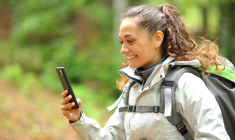Jeune femme faisant une balade en forêt en suivant les conseils de locaux sur une appli
