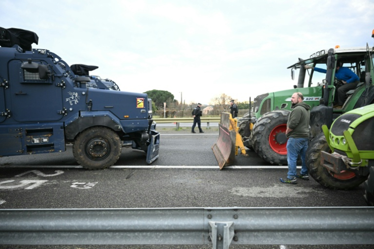 Un agriculteur du groupe des "Ultras de l'A64" fait face à un véhicule blindé Centaure de la gendarmerie sur le barrage de l'autoroute A64 à Carbonne, le 13 janvier 2026 en Haute-Garonne ( AFP / Lionel BONAVENTURE )