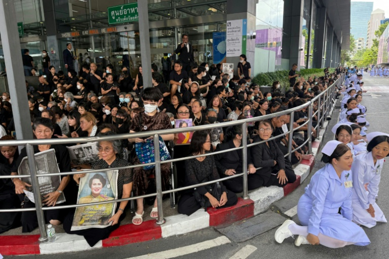 Des habitants et des infirmières rendent hommage à la dépouille de la reine mère Sirikit, à son départ de l'hôpital Chulalongkorn jusqu'au palais royal de Bangkok, le 26 octobre 2025 ( AFP / Watsamon TRI-YASAKDA )